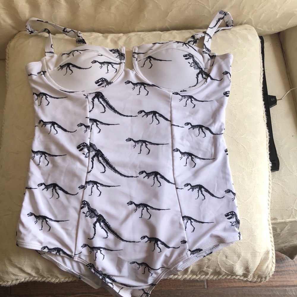 Dinosaur print bathing suit. Seems like small with long torso., small cups .